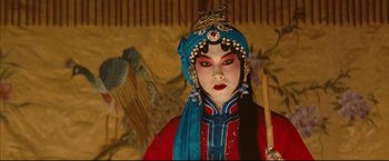 Movie still from “The Painted Veil” (2006), directed by John Curran – A woman in a blue headdress and red outfit; Close Up shot, Over the shoulder angle