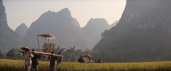 Movie still from “The Painted Veil” (2006), directed by John Curran – A group of people standing on top of a grass covered field; Extreme Wide shot, Low angle