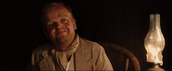 Movie still from “The Painted Veil” (2006), directed by John Curran – A person sitting in a chair wearing a neck tie; Close Up shot, Over the shoulder angle