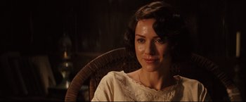 Movie still from “The Painted Veil” (2006), directed by John Curran – A woman sitting in a wicker chair in the dark; Close Up shot, Over the shoulder angle