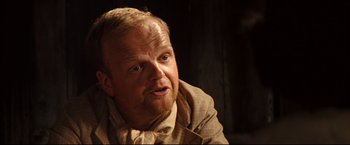 Movie still from “The Painted Veil” (2006), directed by John Curran – A person wearing a suit and tie; Close Up shot, Over the shoulder angle