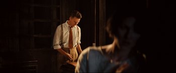 Movie still from “The Painted Veil” (2006), directed by John Curran – A man wearing a tie standing in front of a mirror; Medium shot, Over the shoulder angle