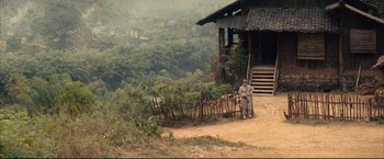 Movie still from “The Painted Veil” (2006), directed by John Curran – A man standing next to a fence on a dirt hill; Extreme Wide shot, High angle