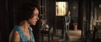 Movie still from “The Painted Veil” (2006), directed by John Curran – A woman looking at a man sweeping the floor; Medium shot, Over the shoulder angle