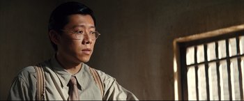 Movie still from “The Painted Veil” (2006), directed by John Curran – A man wearing glasses and a tan shirt; Close Up shot, Low angle