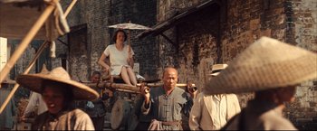 Movie still from “The Painted Veil” (2006), directed by John Curran – An old man holding a stick with a woman sitting on top of it; Wide shot, High angle