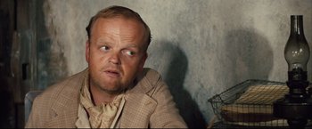 Movie still from “The Painted Veil” (2006), directed by John Curran – A person wearing a suit and tie; Close Up shot, Over the shoulder angle