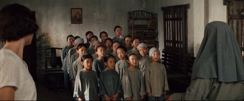 Movie still from “The Painted Veil” (2006), directed by John Curran – A group of children standing together in a room; Wide shot, High angle