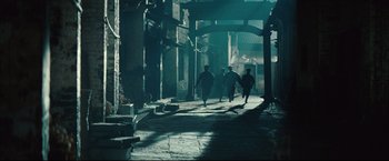 Movie still from “The Painted Veil” (2006), directed by John Curran – A group of people walking down a street in the dark; Wide shot, High angle