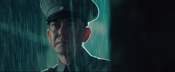 Movie still from “The Painted Veil” (2006), directed by John Curran – A man wearing a uniform and hat in the rain; Close Up shot, Low angle