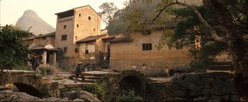 Movie still from “The Painted Veil” (2006), directed by John Curran – A group of people sitting on steps near a stone bridge; Extreme Wide shot, High angle