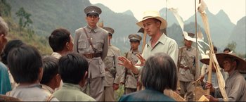 Movie still from “The Painted Veil” (2006), directed by John Curran – A group of men standing next to each other in a field; Medium shot, Over the shoulder angle