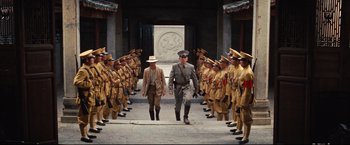 Movie still from “The Painted Veil” (2006), directed by John Curran – A group of men standing next to each other in front of a group of soldiers; Wide shot, Low angle