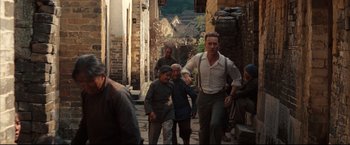 Movie still from “The Painted Veil” (2006), directed by John Curran – A group of people walking down a street; Wide shot, Over the shoulder angle