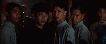 Movie still from “The Painted Veil” (2006), directed by John Curran – A group of men standing next to each other in a room; Close Up shot, Over the shoulder angle