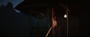Movie still from “The Painted Veil” (2006), directed by John Curran – A man standing on top of a wooden deck; Wide shot, Low angle