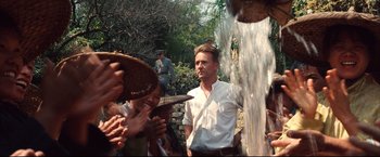 Movie still from “The Painted Veil” (2006), directed by John Curran – A group of people standing next to each other near a fountain; Medium shot, Over the shoulder angle