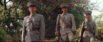 Movie still from “The Painted Veil” (2006), directed by John Curran – A couple of men standing next to each other in uniform; Medium shot, Low angle