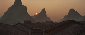 Movie still from “The Painted Veil” (2006), directed by John Curran – The sun is setting over a mountain range; Extreme Wide shot, Low angle