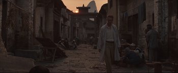 Movie still from “The Painted Veil” (2006), directed by John Curran – A man walking down a street in the middle of the day; Wide shot, Low angle