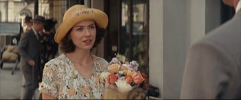 Movie still from “The Painted Veil” (2006), directed by John Curran – A woman holding a bouquet of flowers in her hand; Close Up shot, Over the shoulder angle