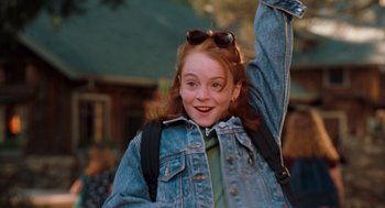 Movie still from “The Parent Trap” (1998), directed by Nancy Meyers – A young girl with a backpack and sun glasses waving; Medium shot, High angle