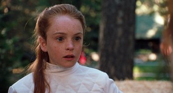 Movie still from “The Parent Trap” (1998), directed by Nancy Meyers – A young girl in a white jacket looking at the camera; Close Up shot, Over the shoulder angle