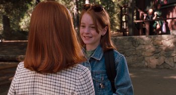 Movie still from “The Parent Trap” (1998), directed by Nancy Meyers – A young girl with a backpack talking to a woman in a park; Close Up shot, Over the shoulder angle