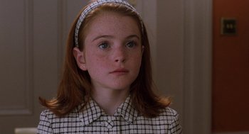 Movie still from “The Parent Trap” (1998), directed by Nancy Meyers – A young girl wearing a checkered shirt and a headband; Close Up shot, High angle