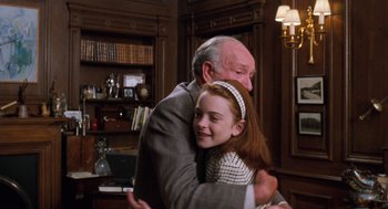 Movie still from “The Parent Trap” (1998), directed by Nancy Meyers – An older man hugging a young girl in front of a bookcase; Medium shot, Low angle