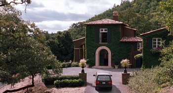 Movie still from “The Parent Trap” (1998), directed by Nancy Meyers – A car is parked in front of a large house; Extreme Wide shot, Low angle