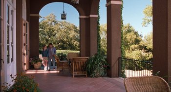 Movie still from “The Parent Trap” (1998), directed by Nancy Meyers – Two people are sitting on a porch with chairs and tables; Wide shot, High angle