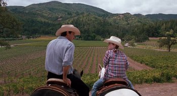 Movie still from “The Parent Trap” (1998), directed by Nancy Meyers – A man and a woman on horses in a field; Wide shot, Over the shoulder angle