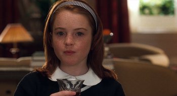 Movie still from “The Parent Trap” (1998), directed by Nancy Meyers – A young girl holding a wine glass in her hand; Close Up shot, High angle