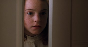 Movie still from “The Parent Trap” (1998), directed by Nancy Meyers – A young girl is standing in a doorway looking at the camera; Close Up shot, High angle