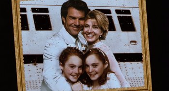 Movie still from “The Parent Trap” (1998), directed by Nancy Meyers – A man and two women and a little girl are posing for a picture; Medium shot, Overhead angle