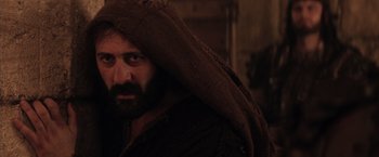 Movie still from “The Passion of the Christ” (2004), directed by Mel Gibson – A man with a beard is wrapped in a blanket; Close Up shot, Over the shoulder angle