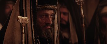 Movie still from “The Passion of the Christ” (2004), directed by Mel Gibson – A man with a long beard wearing a headdress; Close Up shot, Over the shoulder angle