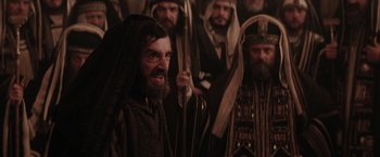 Movie still from “The Passion of the Christ” (2004), directed by Mel Gibson – A group of men standing next to each other in a room; Medium shot, Low angle