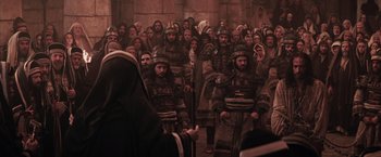 Movie still from “The Passion of the Christ” (2004), directed by Mel Gibson – A group of men in medieval garb standing in front of an audience; Wide shot, High angle