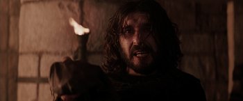 Movie still from “The Passion of the Christ” (2004), directed by Mel Gibson – A man with long hair and a goateed face; Close Up shot, Low angle