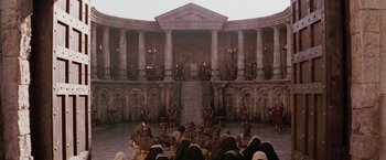 Movie still from “The Passion of the Christ” (2004), directed by Mel Gibson – A group of people sitting in front of a large building; Extreme Wide shot, High angle