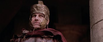 Movie still from “The Passion of the Christ” (2004), directed by Mel Gibson – A man wearing a helmet and a leather outfit; Close Up shot, Low angle