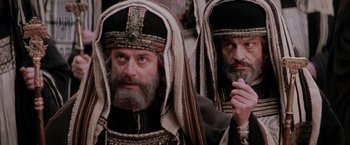 Movie still from “The Passion of the Christ” (2004), directed by Mel Gibson – Two bearded men in medieval garb , one of which has a beard and one of which has a turban; Close Up shot, Low angle