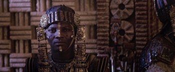 Movie still from “The Passion of the Christ” (2004), directed by Mel Gibson – A man wearing a metal head dress and a metal helmet; Close Up shot, Low angle