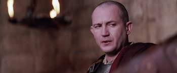 Movie still from “The Passion of the Christ” (2004), directed by Mel Gibson – A man with a bald head wearing a red scarf; Close Up shot, Over the shoulder angle