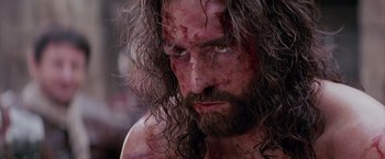 Movie still from “The Passion of the Christ” (2004), directed by Mel Gibson – A person with blood on their face; Close Up shot, Low angle