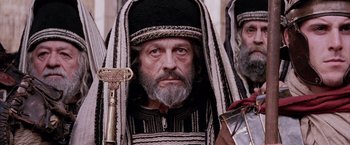 Movie still from “The Passion of the Christ” (2004), directed by Mel Gibson – An old man with a long beard wearing a hat and holding a key; Close Up shot, High angle