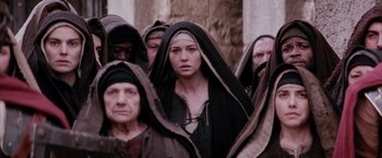Movie still from “The Passion of the Christ” (2004), directed by Mel Gibson – A group of people standing next to each other wearing hoods; Medium shot, Low angle
