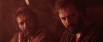 Movie still from “The Passion of the Christ” (2004), directed by Mel Gibson – A man with a goatee is looking at the camera; Close Up shot, Over the shoulder angle